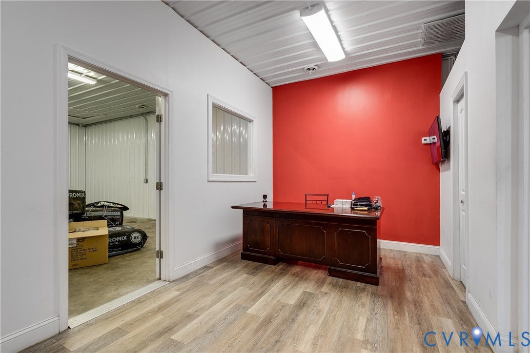 3300 Hull Street, Richmond, VA 23224 Interior space featuring wood-finish flooring, a metal corrugated ceiling, a fixed wall window, and integrated linear lighting