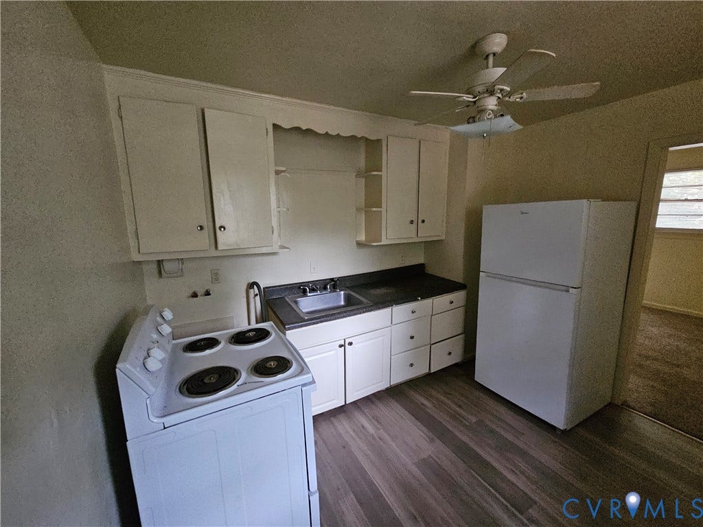 Kitchen featuring white cabinetry, wood-finish flooring, a stainless steel sink, a top-mount electric range, and a ceiling-mounted fan