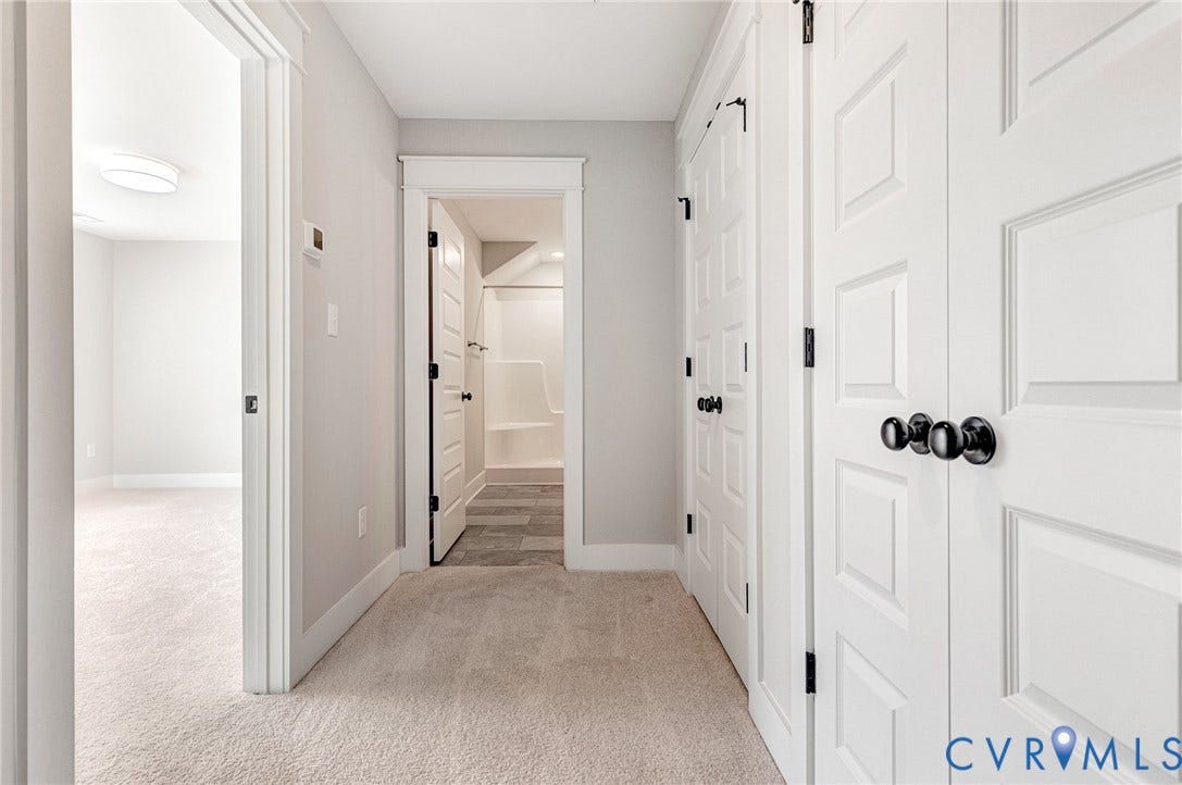 8860 Emily Jane Place, Quinton, VA 23141 The property features light-colored carpeting throughout the hallway and into an adjacent room
