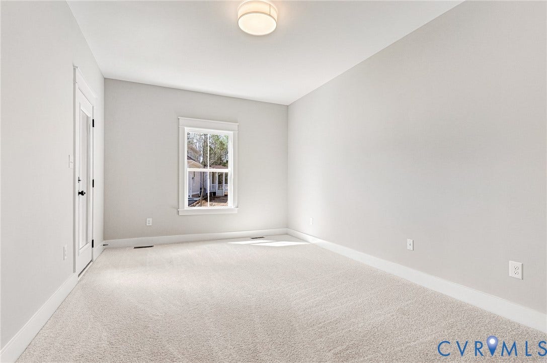 8860 Emily Jane Place, Quinton, VA 23141 This room features light-colored walls and carpeting, a window with trim, and a door with a glass panel
