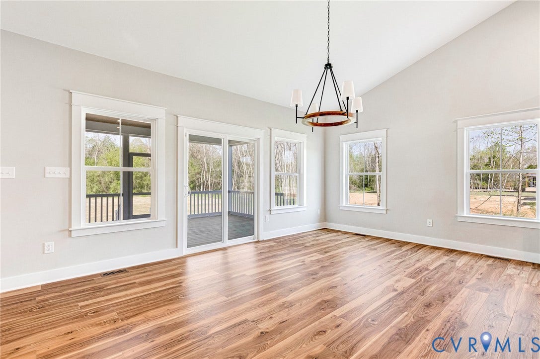 8860 Emily Jane Place, Quinton, VA 23141 Spacious room featuring vaulted ceilings, a contemporary chandelier, and hardwood floors