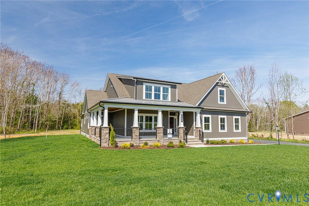 8860 Emily Jane Place, Quinton, VA 23141 The property features a charming front porch with white columns and stone accents, a well-maintained green lawn, and a light brown roof