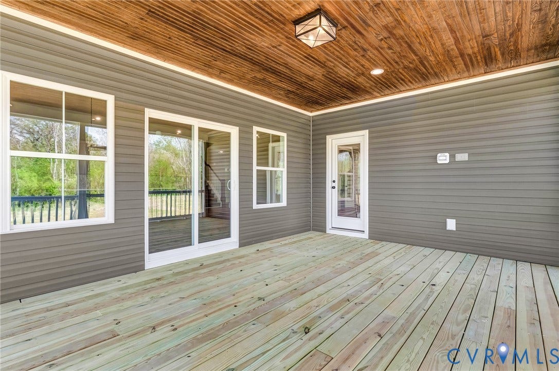 8860 Emily Jane Place, Quinton, VA 23141 The property features an outdoor patio with a wooden deck, gray siding, and a wood plank ceiling