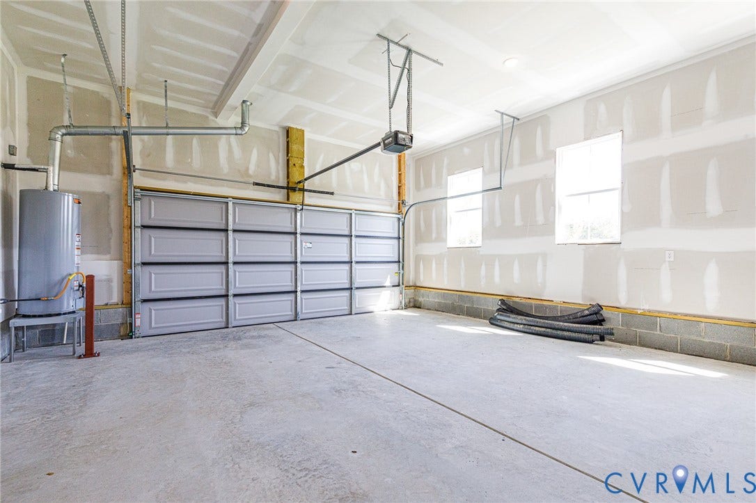 8860 Emily Jane Place, Quinton, VA 23141 Spacious garage with a concrete floor, a light-colored sectional garage door, and two windows providing natural light