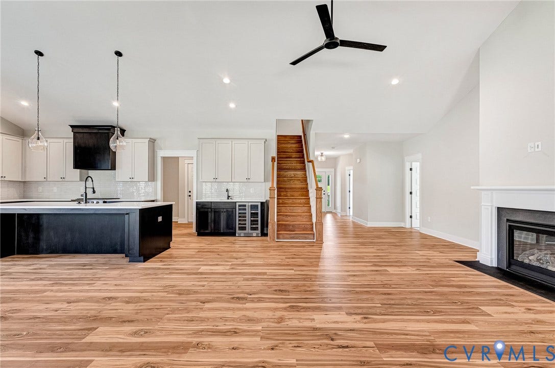 8860 Emily Jane Place, Quinton, VA 23141 The main living area features hardwood floors, a fireplace with a white mantel, and a ceiling fan