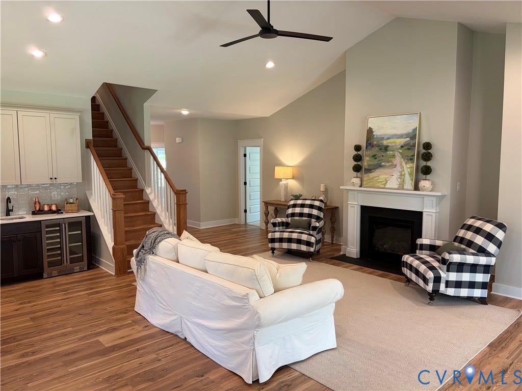 8860 Emily Jane Place, Quinton, VA 23141 Spacious living area featuring vaulted ceilings, a built-in fireplace with white mantel, and wood-finish flooring