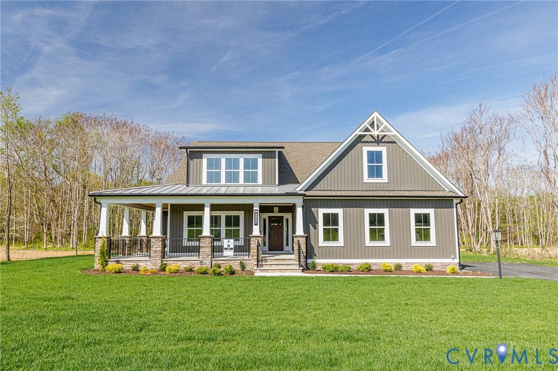 8860 Emily Jane Place, Quinton, VA 23141 The property features a charming exterior with grey siding, a covered porch with white pillars and stone accents, and an expansive front lawn