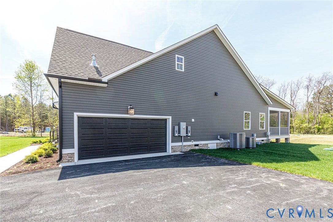 8860 Emily Jane Place, Quinton, VA 23141 The property features dark gray siding, a black garage door, and a screened porch