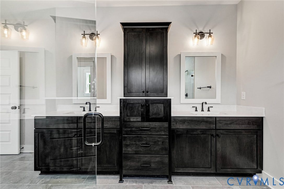 8860 Emily Jane Place, Quinton, VA 23141 Well-appointed bathroom featuring dual vanities with dark wood cabinetry and white countertops, illuminated by wall-mounted light fixtures