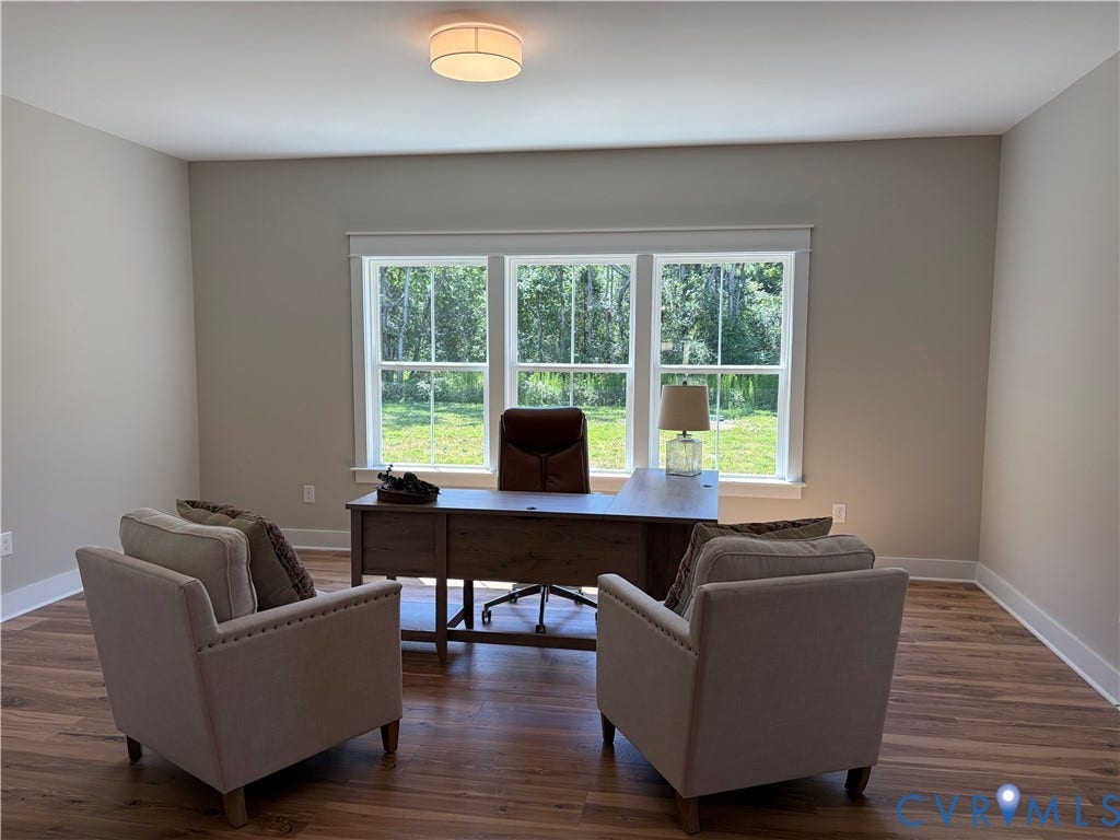 8860 Emily Jane Place, Quinton, VA 23141 Spacious interior room featuring wood-finish flooring, neutral wall tones, and extensive natural light from a triple window unit