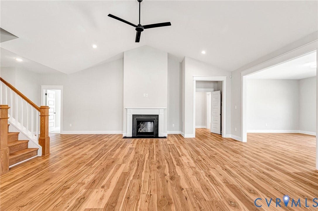 8860 Emily Jane Place, Quinton, VA 23141 Spacious living area featuring hardwood flooring, a fireplace with a white mantel, and a ceiling fan