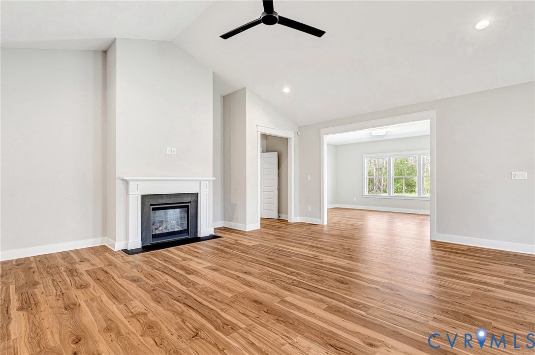 8860 Emily Jane Place, Quinton, VA 23141 Spacious interior featuring wood-style flooring, a white mantel fireplace, and a black ceiling fan