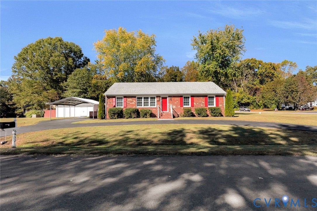 6432 Bellflower Circle, Mechicsville, Mechanicsville, VA 23111 Single-story brick residence featuring a front-facing gable roof, vibrant red exterior shutters, an asphalt driveway, and a detached metal carport