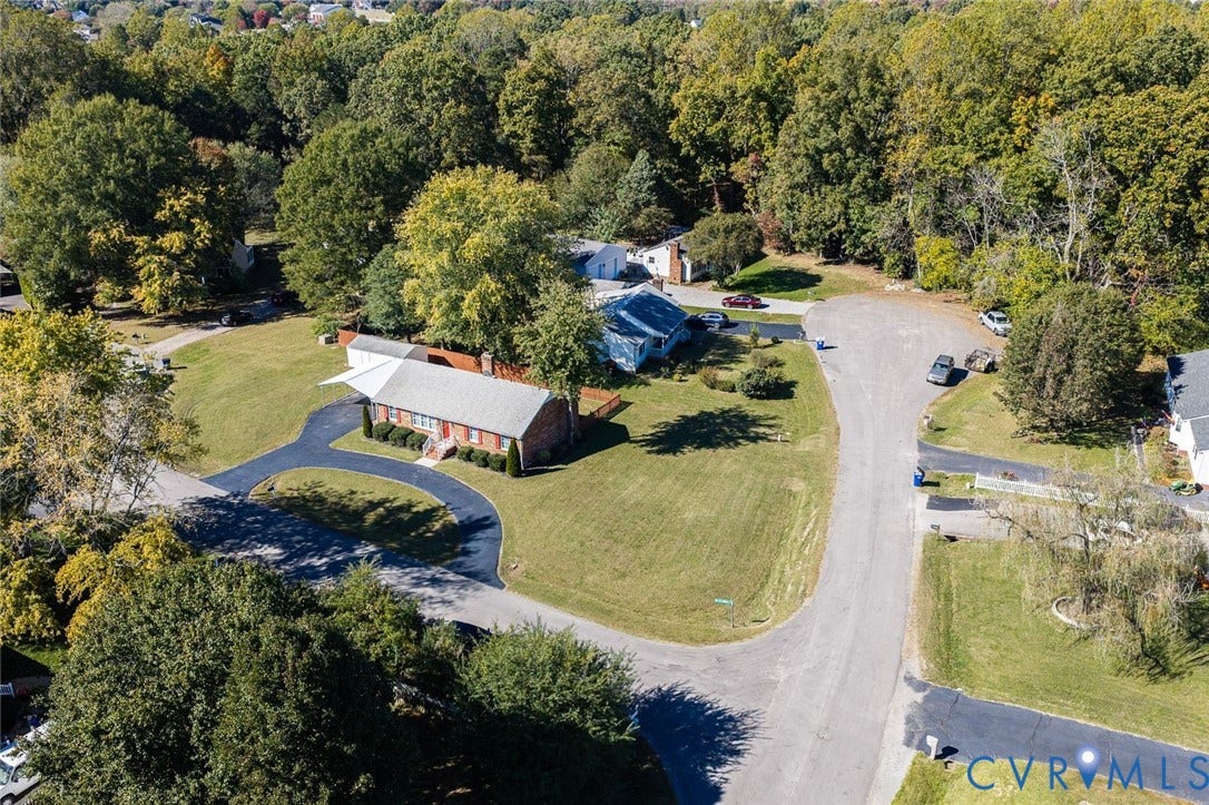 6432 Bellflower Circle, Mechicsville, Mechanicsville, VA 23111 Brick exterior residence featuring a circular asphalt driveway, detached storage structure, and expansive grass lawn situated on a wooded lot