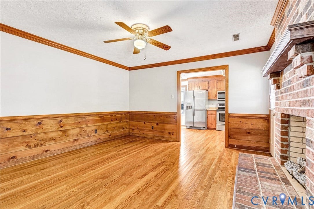 6432 Bellflower Circle, Mechicsville, Mechanicsville, VA 23111 Living area featuring wood-finish flooring, wood wall paneling, crown molding, and a full-height brick fireplace