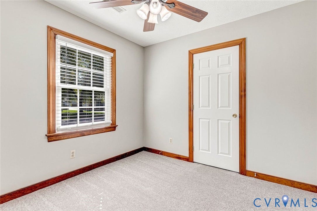 6432 Bellflower Circle, Mechicsville, Mechanicsville, VA 23111 Interior space featuring neutral wall tones, six-panel door with wood-finish trim, window with wood-finish casing, wall-to-wall carpeting, and a ceiling fan with integrated lighting