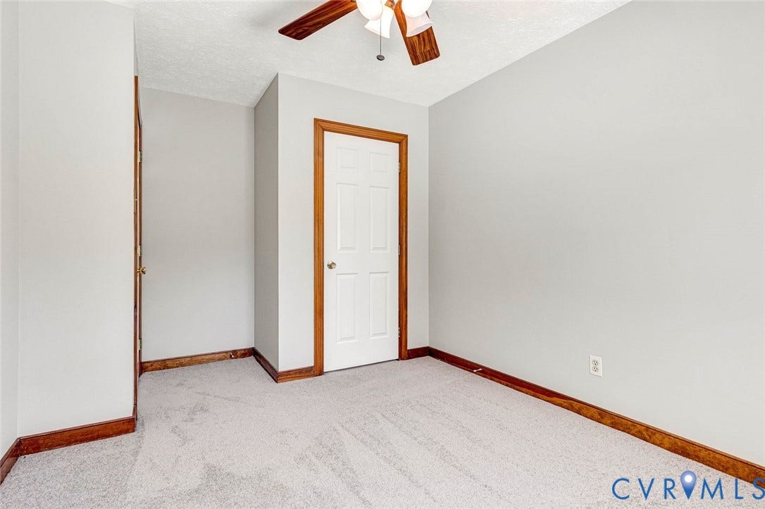 6432 Bellflower Circle, Mechicsville, Mechanicsville, VA 23111 Room featuring neutral-toned carpeting, wood-finished trim, a six-panel door, and a ceiling-mounted fan with light fixture