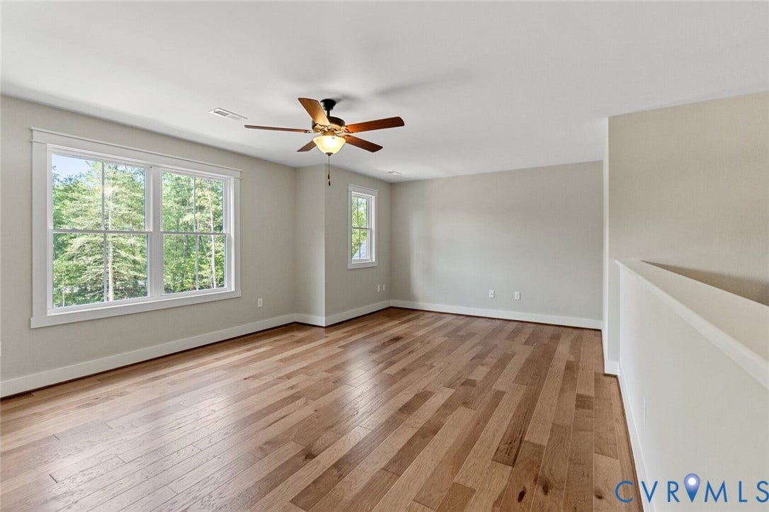 14270 Tower Road, Scotchtown Estates, Montpelier, VA 23047 Spacious room featuring wood-finish flooring, multi-pane windows, a ceiling fan with light fixture, and neutral wall tones