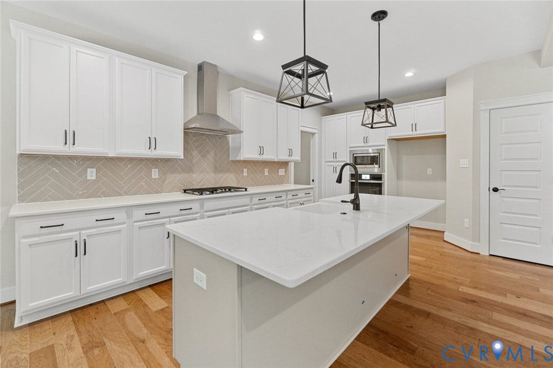 14270 Tower Road, Scotchtown Estates, Montpelier, VA 23047 Kitchen featuring white cabinetry, center island with stone countertop, herringbone-patterned backsplash, stainless steel range hood, and wood-finish flooring