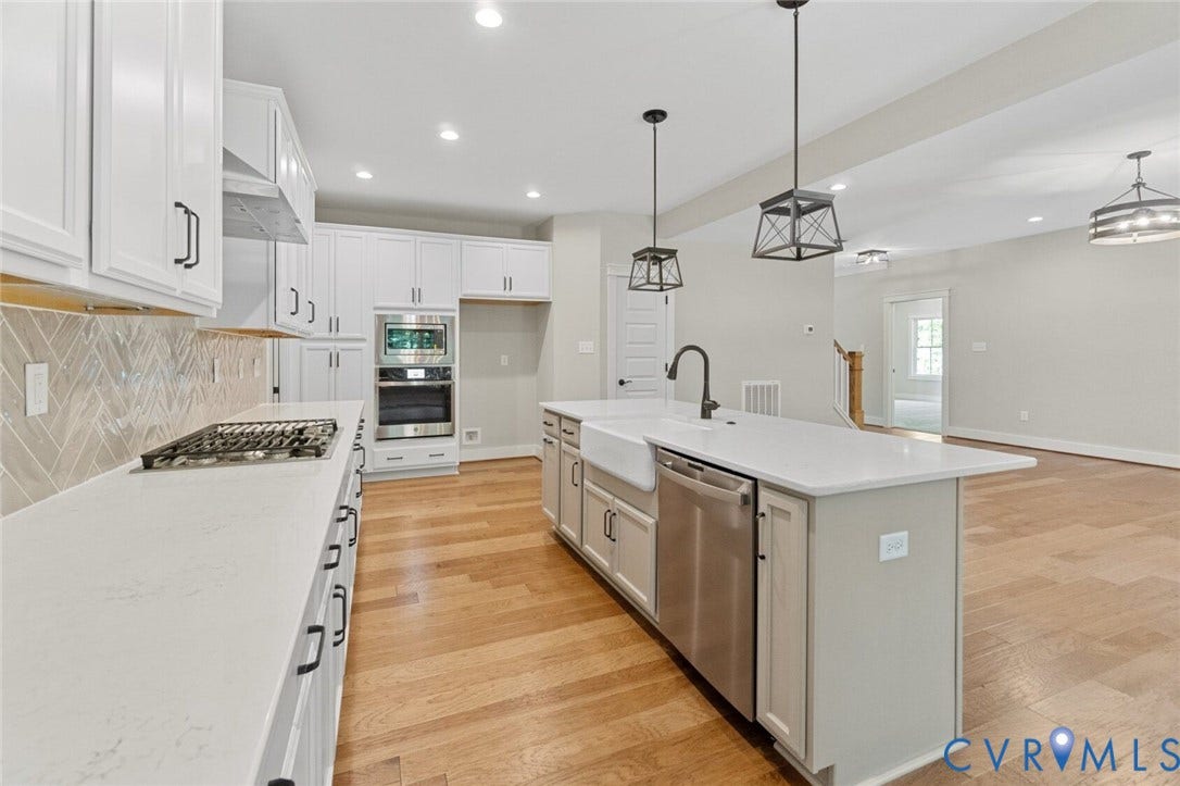 14270 Tower Road, Scotchtown Estates, Montpelier, VA 23047 Kitchen featuring white cabinetry, wood-finish flooring, a farmhouse sink with a matte black faucet, herringbone-pattern tile backsplash, and stainless steel built-in appliances