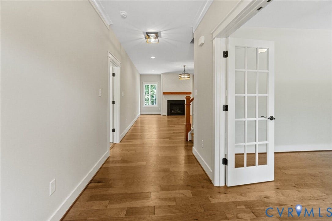 14270 Tower Road, Scotchtown Estates, Montpelier, VA 23047 Interior hall featuring wood-finish flooring, white French doors with glass panes, crown molding, recessed lighting, and a fireplace with a wood mantel