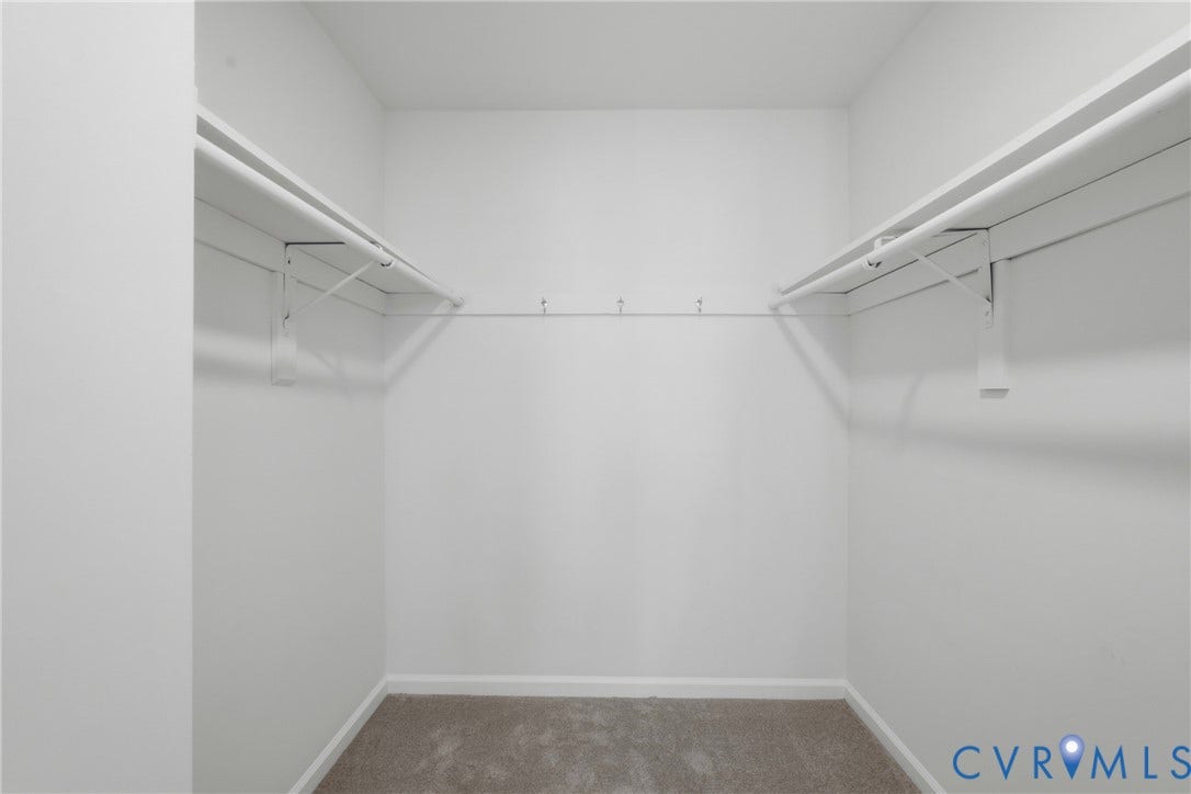 12506 Mandolin Drive, Chesterfield, VA 23113 Walk-in closet featuring neutral carpeted flooring, white walls, and dual-level built-in shelving with integrated garment rods