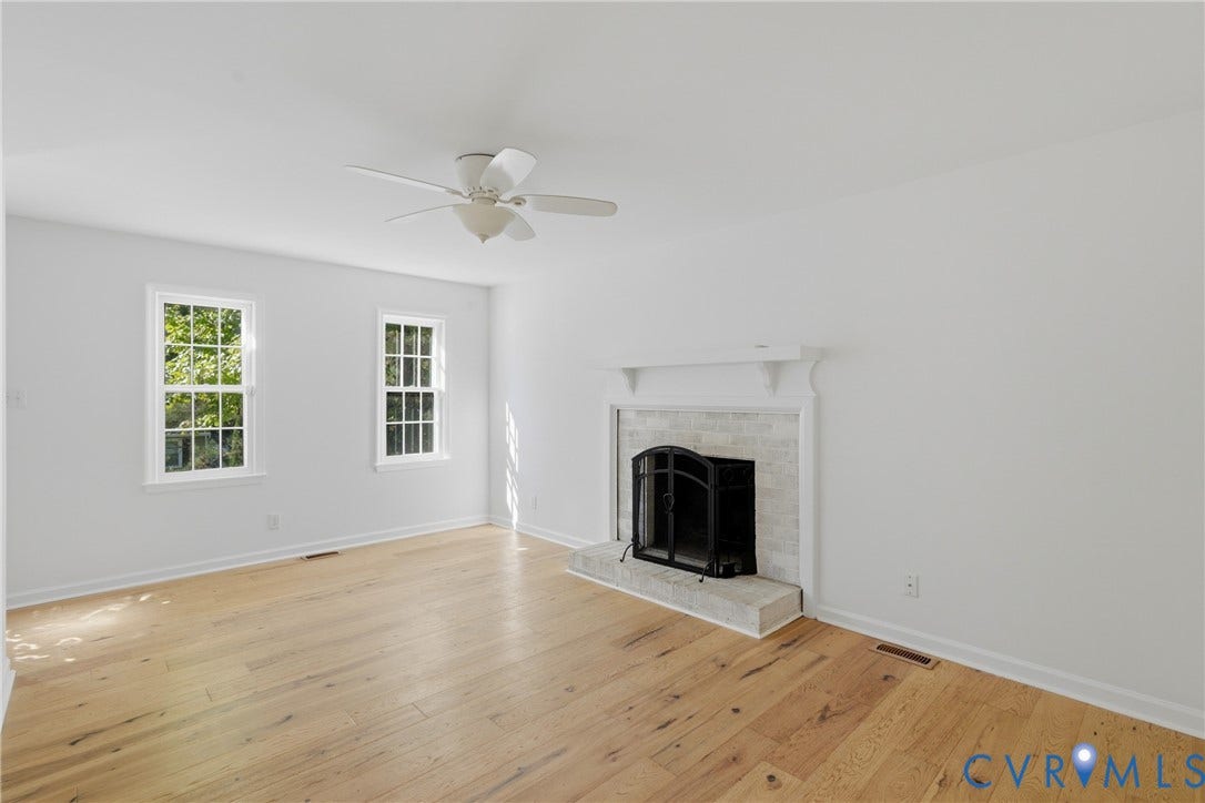 12506 Mandolin Drive, Chesterfield, VA 23113 Living area featuring wood-finish flooring, a masonry fireplace with a brick-surround hearth, a traditional mantel, and a ceiling-mounted fan