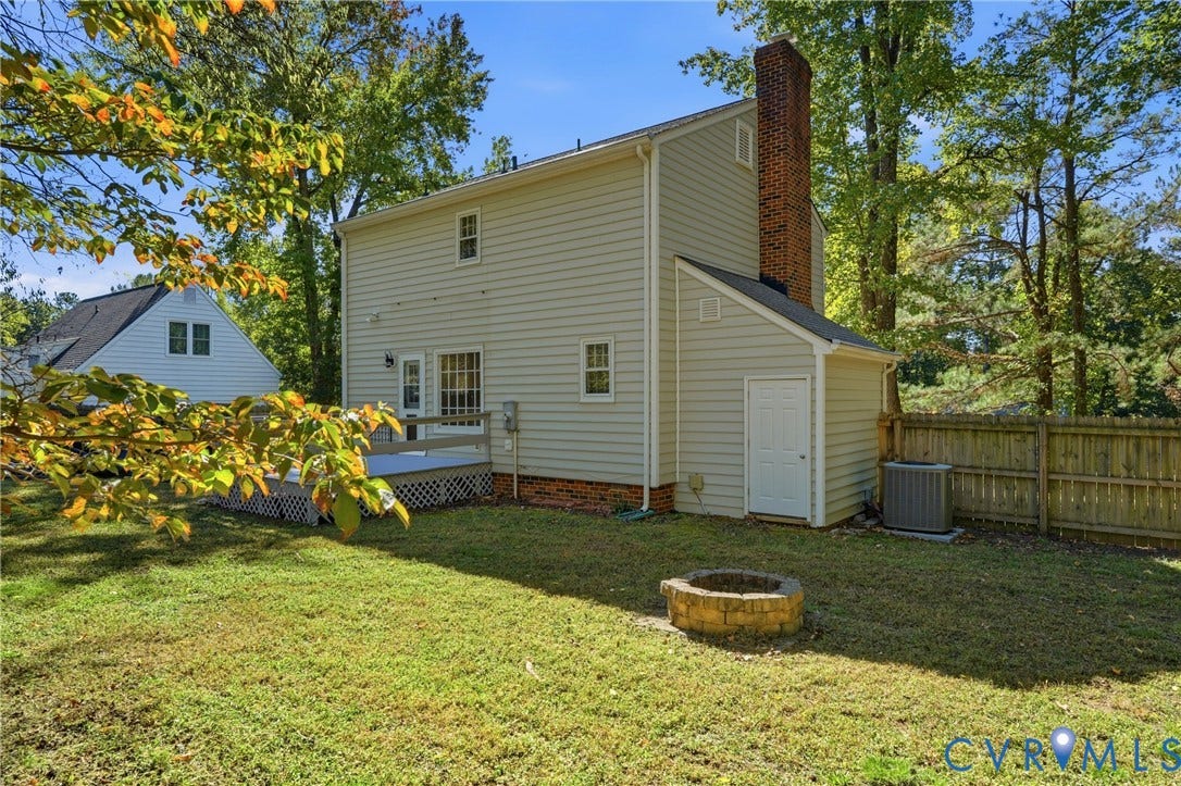 12506 Mandolin Drive, Chesterfield, VA 23113 Rear exterior featuring light-toned siding, a brick chimney, a wood-frame deck and a wooden privacy fence