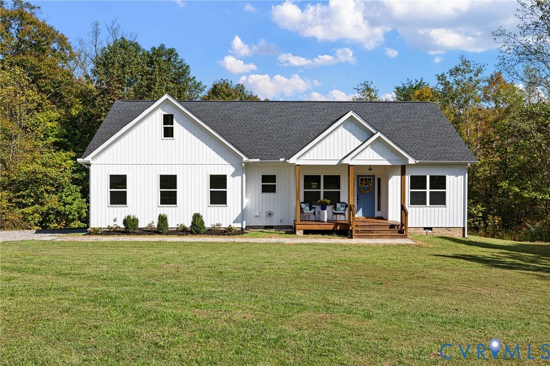 360 Anderson Mill Drive, Anderson Mill, Bumpass, VA 23024 White vertical siding exterior featuring a covered front porch, dark-toned asphalt shingle roof, stone foundation trim, and double-hung windows