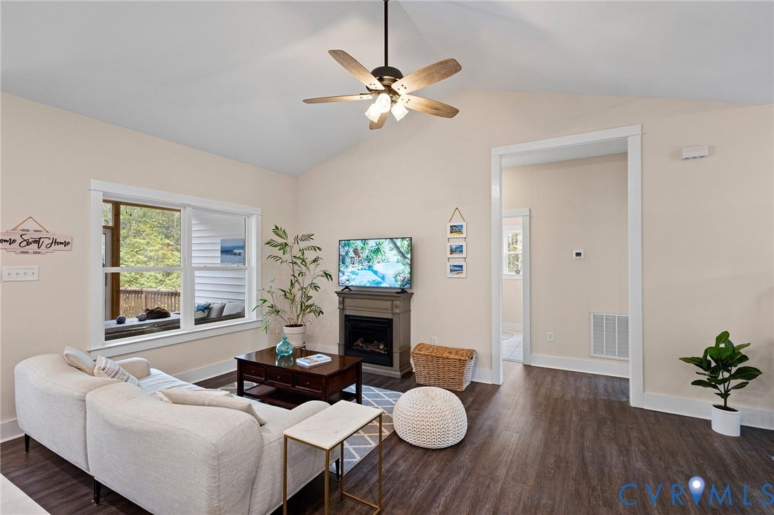 360 Anderson Mill Drive, Anderson Mill, Bumpass, VA 23024 Vaulted ceiling with an integrated multi-blade ceiling fan, wood-finish flooring, and a decorative fireplace mantel