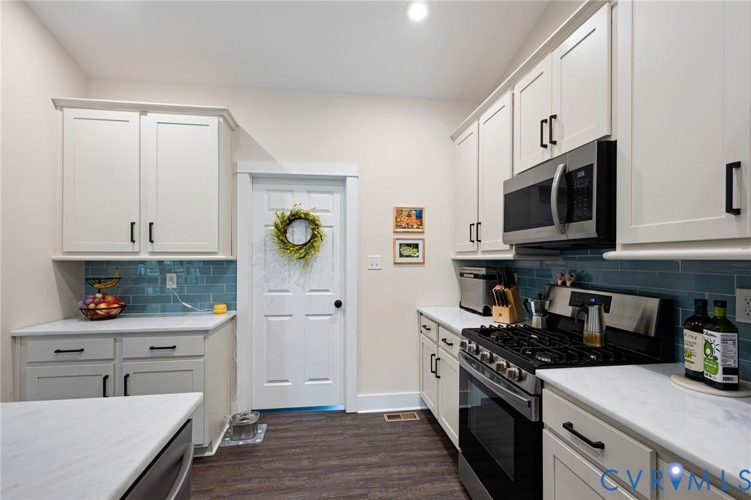 360 Anderson Mill Drive, Anderson Mill, Bumpass, VA 23024 Kitchen featuring shaker-style cabinetry with matte black hardware, stone-composite countertops, blue subway tile backsplash, and dark wood-finish flooring