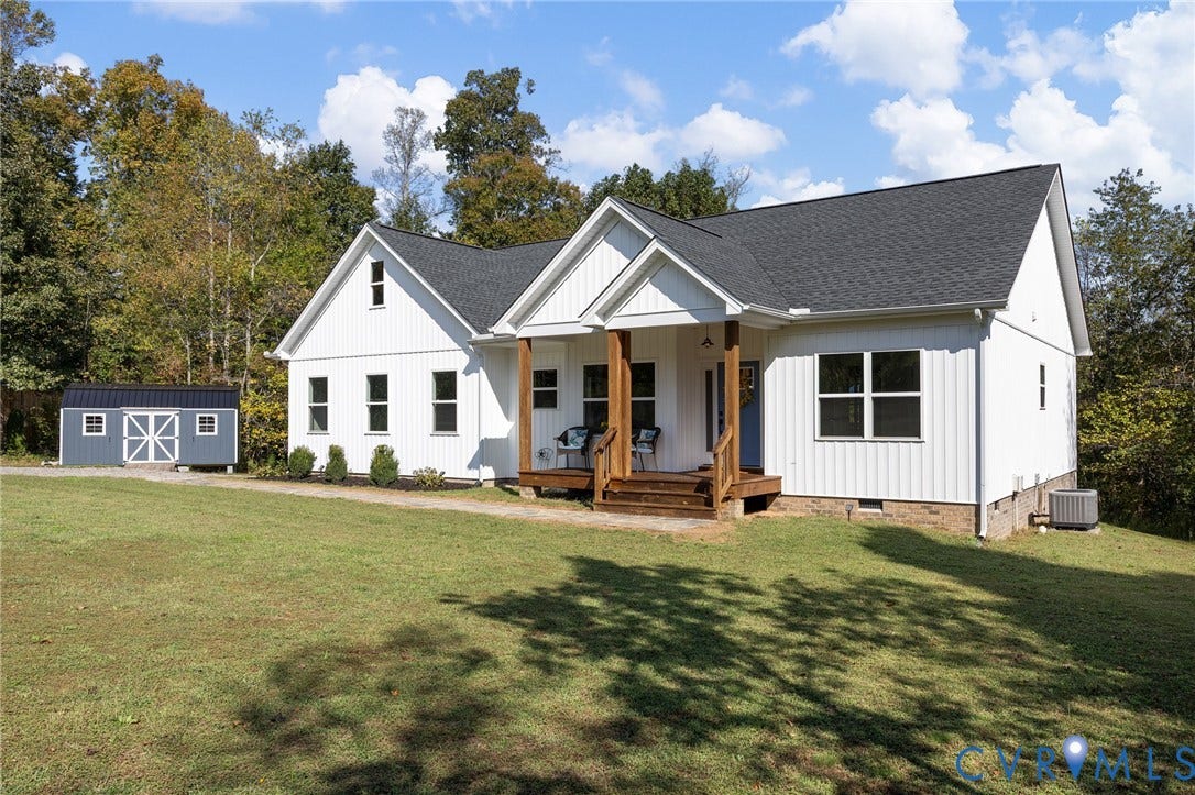 360 Anderson Mill Drive, Anderson Mill, Bumpass, VA 23024 Vertical white siding exterior featuring a gable-roofed covered porch with timber posts, an attached storage structure, and a concrete foundation
