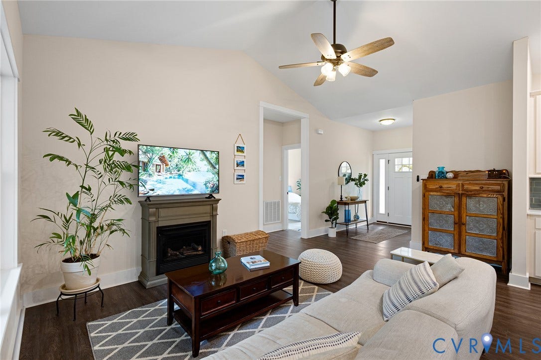 360 Anderson Mill Drive, Anderson Mill, Bumpass, VA 23024 Vaulted ceiling with an integrated multi-blade ceiling fan, wood-finish flooring, and a floor-to-ceiling fireplace mantel
