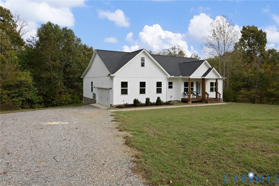 360 Anderson Mill Drive, Anderson Mill, Bumpass, VA 23024 White vertical-siding exterior with a dark shingle roof, covered front porch, and attached garage on a large cleared lot