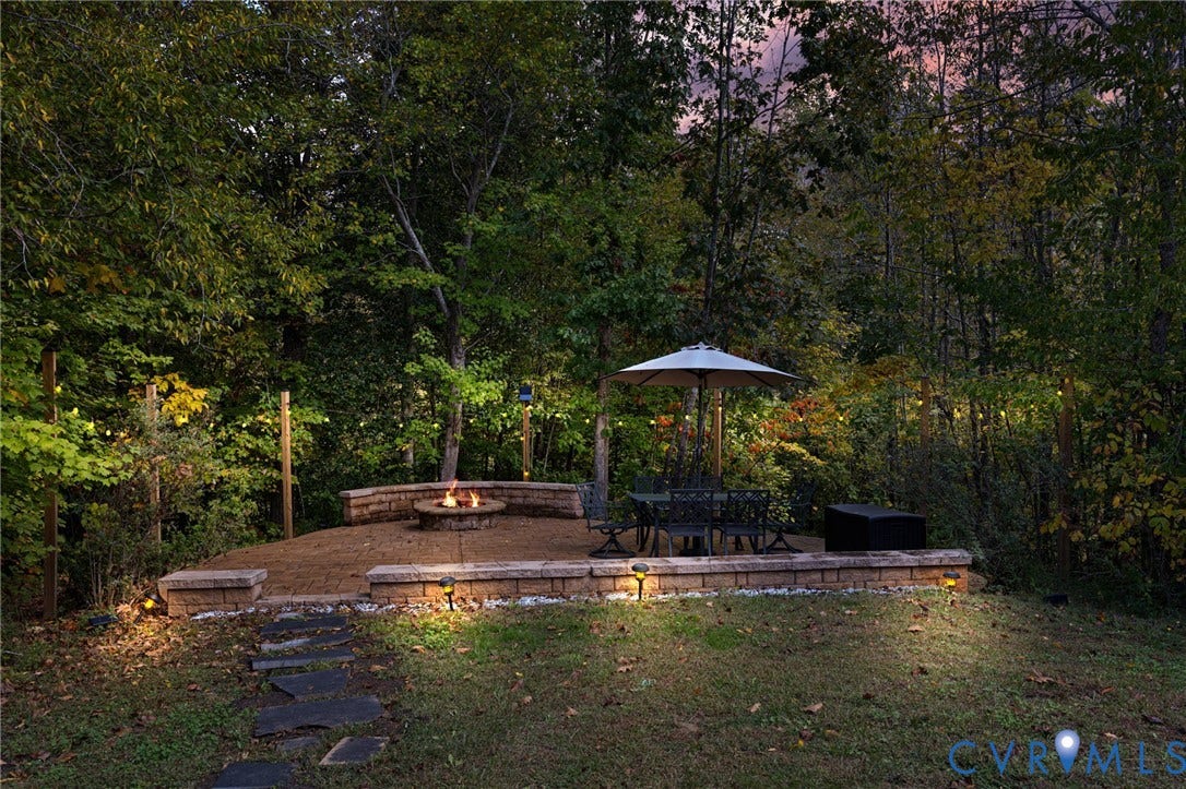 360 Anderson Mill Drive, Anderson Mill, Bumpass, VA 23024 Tiered stone patio featuring a built-in fire pit, stone retaining walls, slate pathway, and string lighting