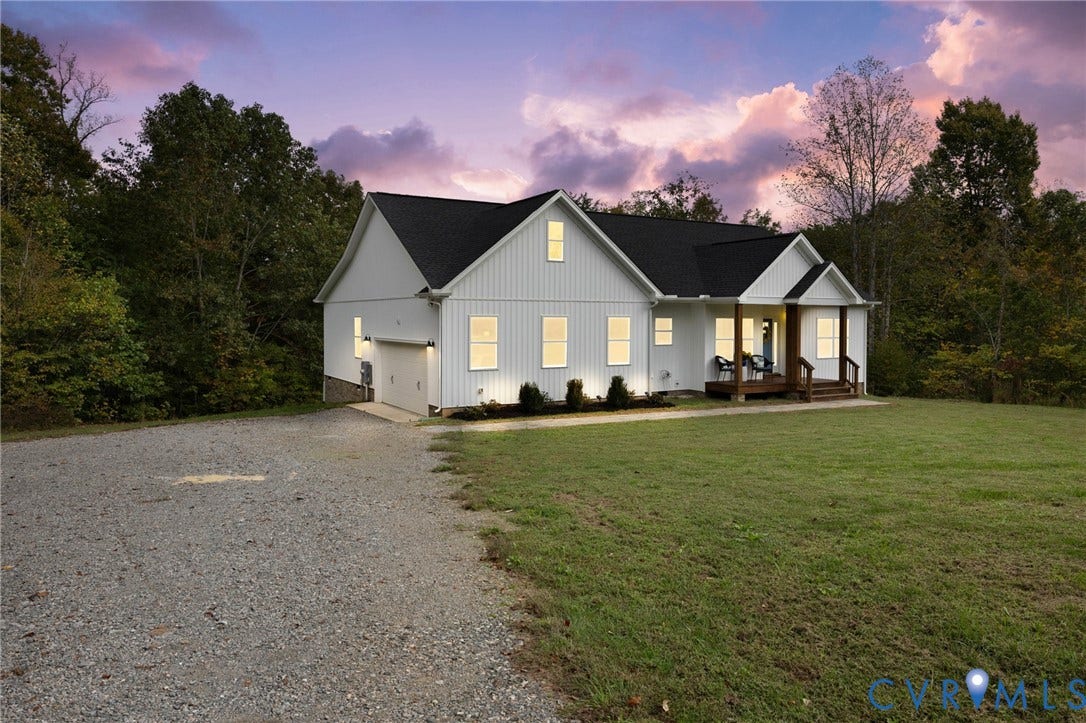 360 Anderson Mill Drive, Anderson Mill, Bumpass, VA 23024 Modern farmhouse exterior featuring vertical board-and-batten siding, a covered front porch, an attached garage, and a gravel driveway
