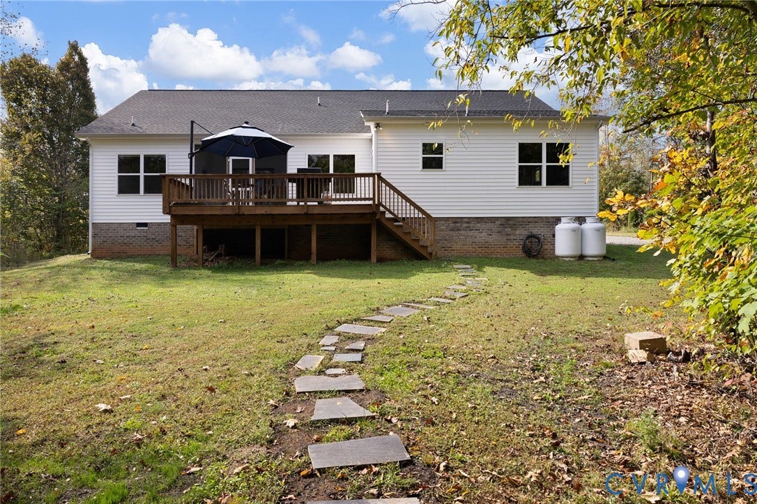 360 Anderson Mill Drive, Anderson Mill, Bumpass, VA 23024 Exterior rear elevation featuring white siding, a brick foundation, an elevated wooden deck with railings, and a flagstone path