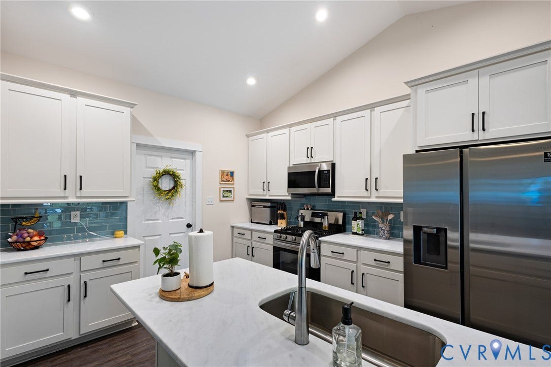 360 Anderson Mill Drive, Anderson Mill, Bumpass, VA 23024 Kitchen featuring white shaker-style cabinetry, a central island with a solid-surface countertop, stainless steel appliances, blue tile backsplash, and recessed lighting
