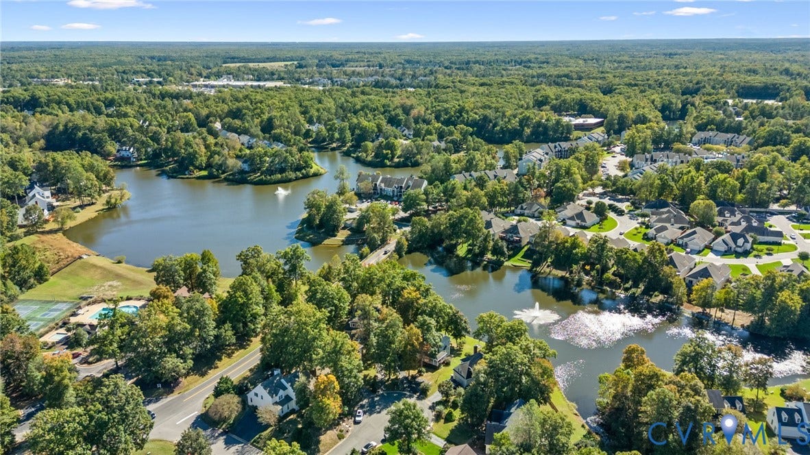 6500 Arbor Landing Drive, Arbor Landing, Chester, VA 23831 Aerial perspective of a multi-acre community featuring expansive water elements, dual decorative fountains, abundant mature tree canopy, and paved roadway infrastructure