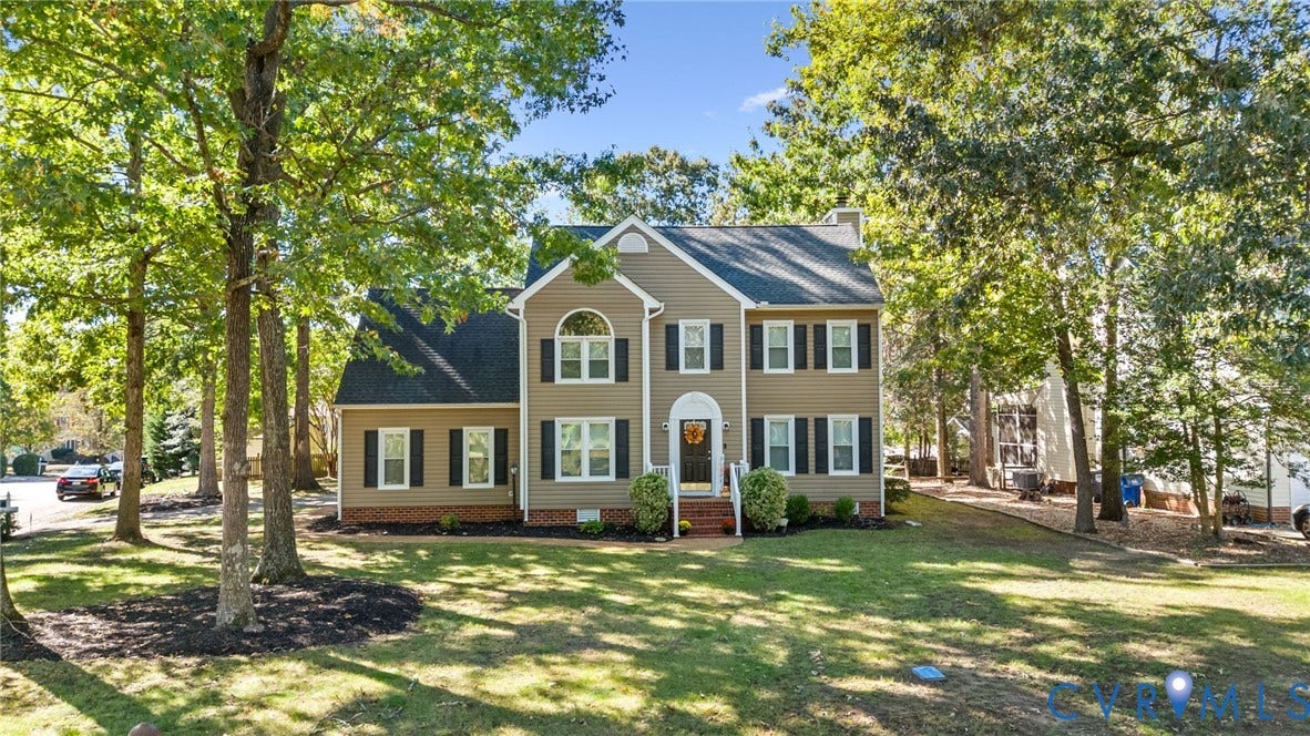 6500 Arbor Landing Drive, Arbor Landing, Chester, VA 23831 Two-story residence featuring tan lap siding, a dark-toned shingled roof, arched accent window, brick foundation skirting, and shuttered windows