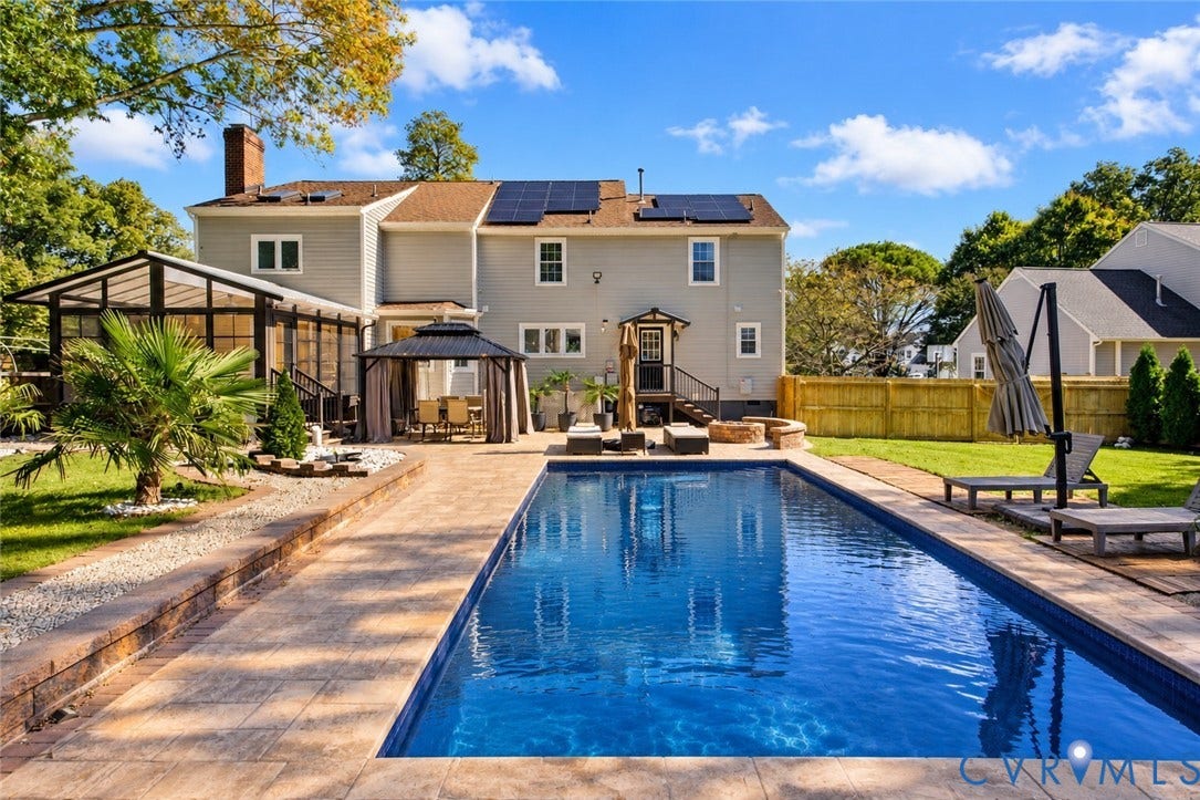 4504 Argonne Court, Glen Allen, VA 23060 *digitally enhanced to remove pool cover* Rear exterior featuring an in-ground swimming pool, stone-paver patio, enclosed sunroom, integrated solar panels, and wood fencing