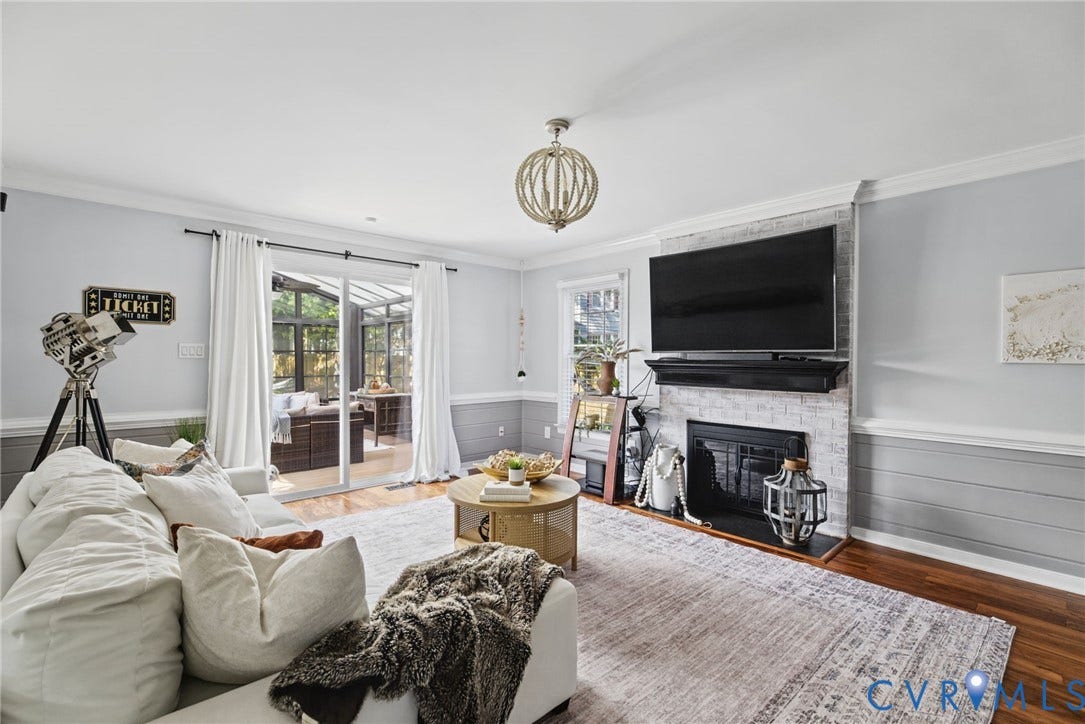 4504 Argonne Court, Glen Allen, VA 23060 Fireplace with a whitewashed brick surround, wood-finish flooring, horizontal shiplap wall paneling, and a geometric chandelier