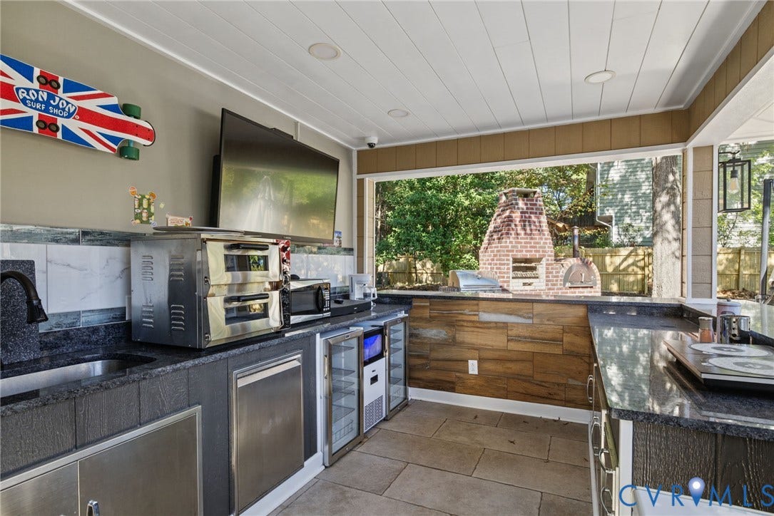 4504 Argonne Court, Glen Allen, VA 23060 Outdoor kitchen featuring stone-finish countertops, stainless steel cabinetry, dual glass-front beverage refrigerators, recessed ceiling lighting, and a wood-fired brick oven