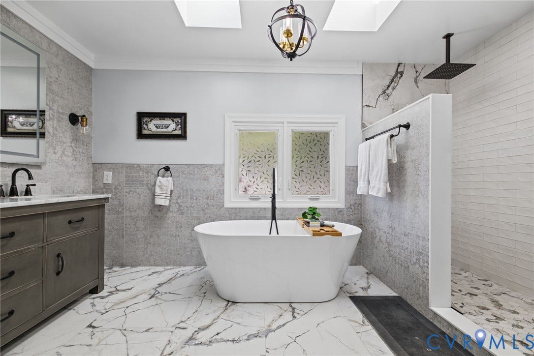 4504 Argonne Court, Glen Allen, VA 23060 Freestanding soaking tub, walk-in shower with rainfall showerhead, dual-toned tiled walls, light-veined stone-patterned flooring, and dual skylights