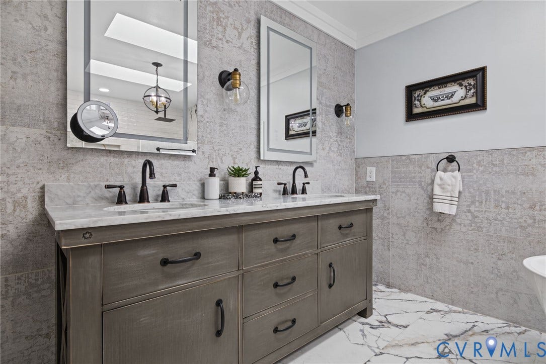 4504 Argonne Court, Glen Allen, VA 23060 Double vanity featuring grey-tone cabinetry, stone countertop with dual undermount sinks, wall-mounted globe lighting, and matte black fixtures