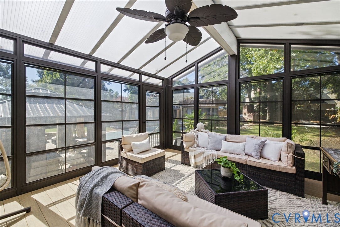 4504 Argonne Court, Glen Allen, VA 23060 Sunroom featuring a vaulted semi-translucent roof, dark-framed grid windows, wood-finish flooring, and a ceiling fan with leaf-motif blades