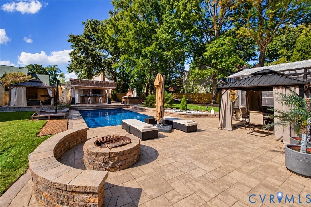 4504 Argonne Court, Glen Allen, VA 23060 *digitally enhanced to remove pool cover* In-ground swimming pool, stone-paver patio, circular masonry fire pit with integrated seating wall, covered outdoor kitchen, and multiple detached covered pavilions