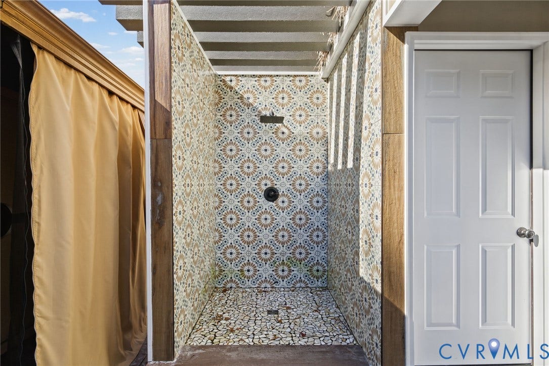 4504 Argonne Court, Glen Allen, VA 23060 Outdoor shower featuring patterned wall tile, pebble-mosaic flooring, a fixed rainfall showerhead, and wood-finish trim