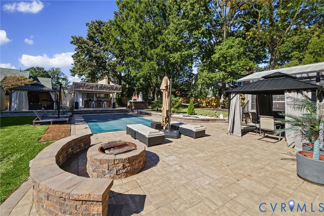 4504 Argonne Court, Glen Allen, VA 23060 Stone paver patio featuring a built-in circular stone fire pit with curved seating, an in-ground swimming pool, a covered outdoor bar area, and multiple permanent metal-frame gazebos