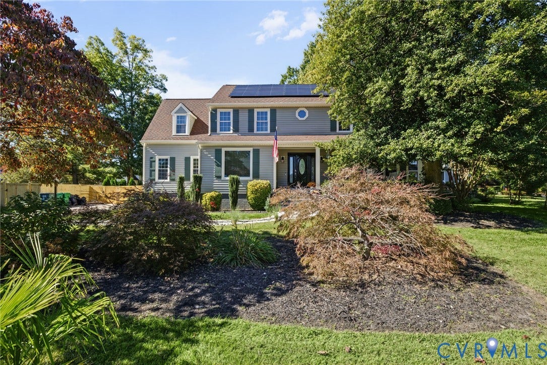 4504 Argonne Court, Glen Allen, VA 23060 Two-story colonial exterior featuring gray siding, a shingle roof with integrated solar panels, dormer windows, and manicured landscaping